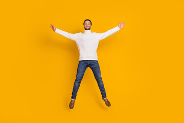 Fototapeta na wymiar Photo of pretty attractive guy wear white pullover jumping high like star isolated yellow color background