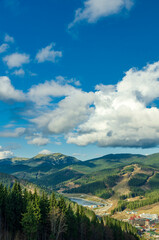 Fototapeta premium Magnificent panoramic view the coniferous forest on the mighty Carpathians Mountains and beautiful blue sky background. Beauty of wild virgin Ukrainian nature. Peacefulness.