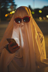 person dressed up as funny ghost texting on phone