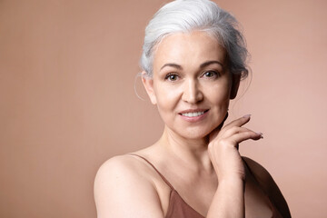 Beautiful  gray-haired senior woman with naked shoulder and perfect groomed skin, studio portrait...