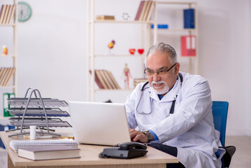 Old male doctor working in the clinic