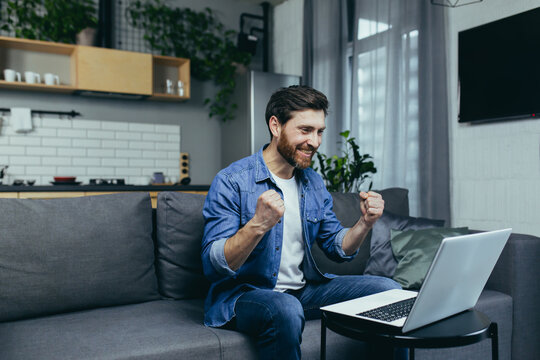 Happy Man Finished Work On The Project, Happy Working At The Computer, Holding Hand Up Victory Gesture, Man At Home Working With Laptop