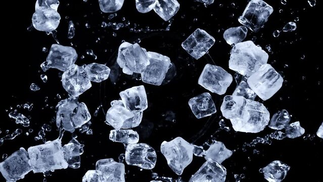 Super slow motion shot of rotating exploded Ice Cubes and splashing water on black at 1000fps.