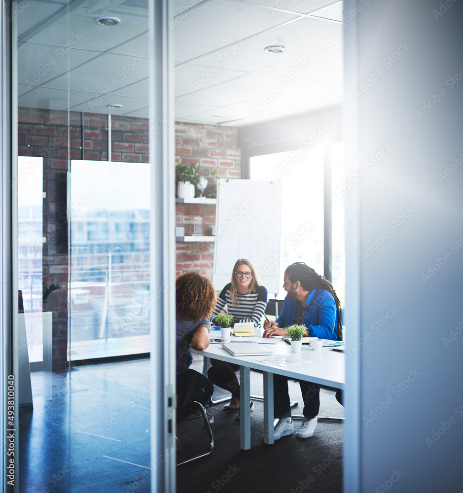 Poster finding a creative way to success. shot of a group of designers having a meeting in an office.
