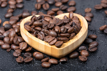 roasted coffee grains on black texture background