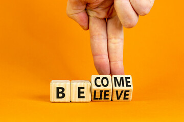Become or believe symbol. Businessman turns wooden cubes and changes the concept word Believe to Become. Beautiful orange table orange background. Business become or believe concept. Copy space.