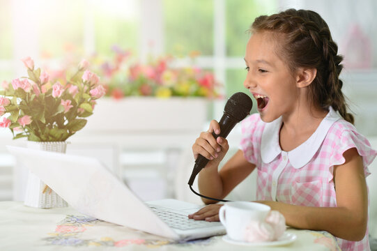 little girl with laptop singing karaoke
