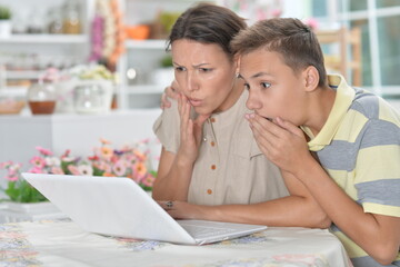 mother and son using modern laptop