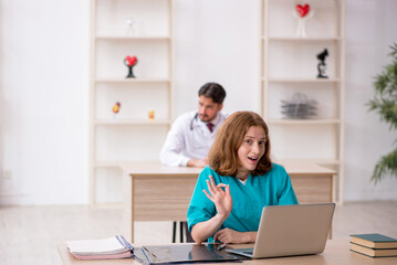 Young male doctor and female assistant working in the clinic