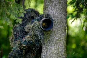 Wildlife photographer in the summer ghillie camouflage suit