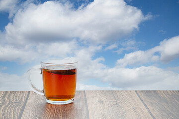 A mug of tea is on the table.A tea bag.Morning tea party.