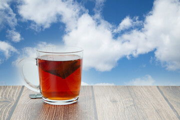A mug of tea is on the table.A tea bag.Morning tea party.