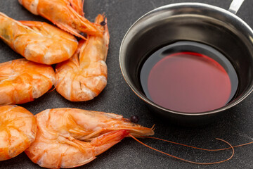 Boiled shrimp and soy sauce in metal bowl.
