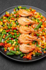 Boiled shrimp and mixed vegetables on black plate