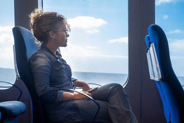 One woman traveling alone inside a ferry cruise with ocean and blue sky view. Concept of transport...