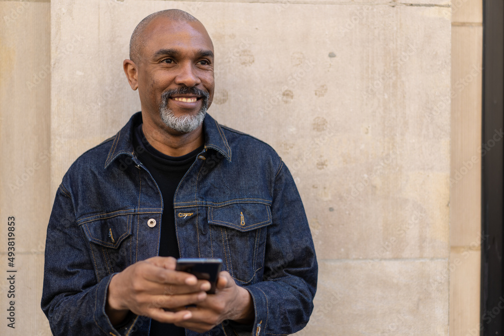 Sticker Mature black man in city using cell phone