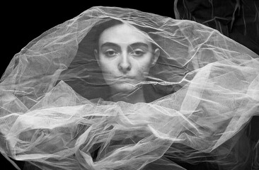 unusually beautiful black and white portrait of a girl wrapped in a veil that separates her beauty from the outside world
