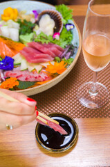 Obraz na płótnie Canvas Woman eating delicious sashimi, closeup on chopsticks.