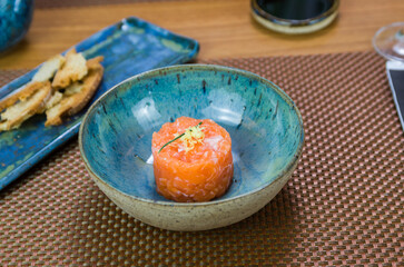 Salmon tartare deliciousness in a beautiful decorated plate.