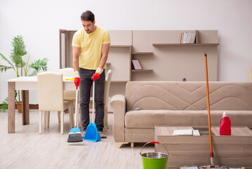 Young male contractor cleaning the house