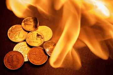 Russian coins, deformed and broken money on fire. The idea of the collapse of the ruble and the...