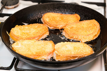 The process of frying bread croutons in an egg in a cast-iron skillet