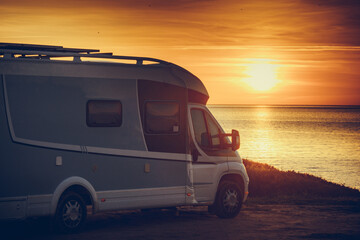 Camper vehicle on beach at sunrise