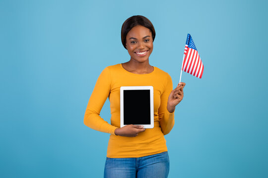 Portrait Of Smiling Black Woman Holding American Flag And Blank Digital Tablet