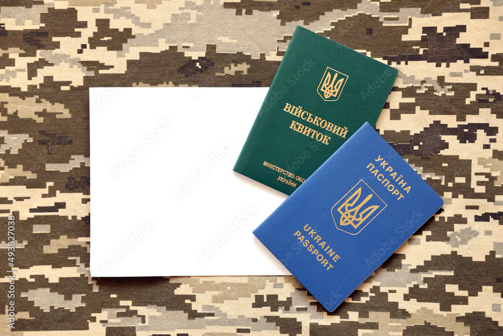 Sticker Ukrainian military ID and foreign passport on fabric with texture of pixeled camouflage. Cloth with camo pattern in grey, brown and green shapes with Ukrainian army personal token and passport.