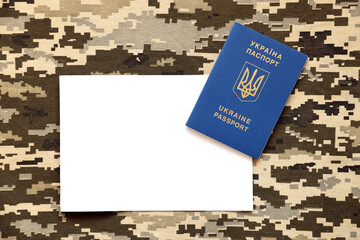 Ukrainian foreign passport on fabric with texture of military pixeled camouflage. Cloth with camo...