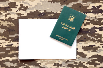 Ukrainian military ID and blank paper sheet on fabric with texture of pixeled camouflage. Cloth...