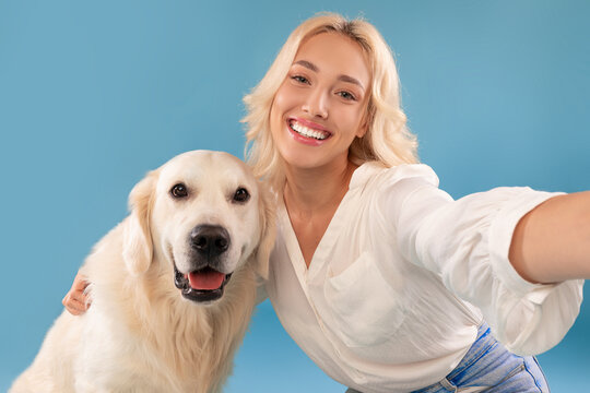 Young woman taking selfie with her happy dog