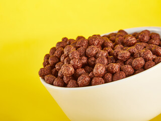 Chocolate Corn balls in bowl over yellow background