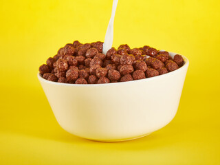 Chocolate Corn balls in bowl over yellow background