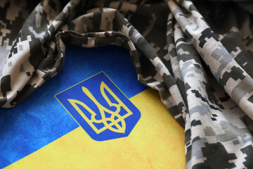 Ukrainian flag and coat of arms with fabric with texture of pixeled camouflage. Cloth with camo...