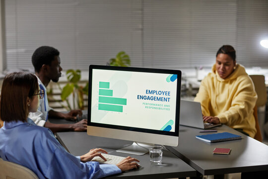 Female marketing manager working with diverse team in office and analyzing data on screen, copy space - Powered by Adobe