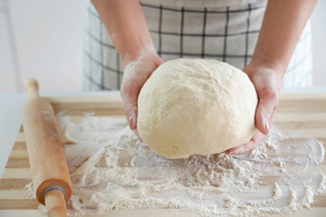 Woman holds dough in her hands and shows at camera. Increasing price of wheat, flour and bread....