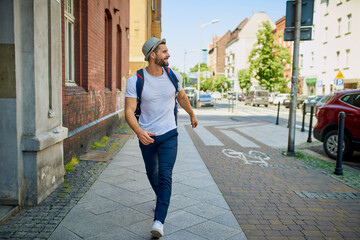 Happy male tourist walking on city street
