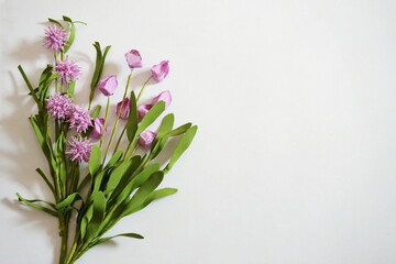 Lavender Posies and Green Leaves on Diagonal on Lower Right Corner of White Background