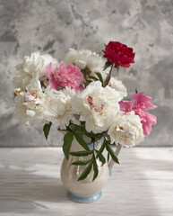 Still life with white and pink peonies in a white vase
