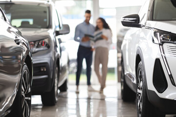 Woman choosing new car, having conversation with sales manager