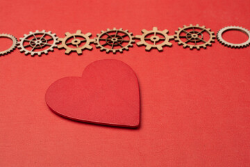 Gear wheels on red Heart shape. Valentine concept and promise of love.
