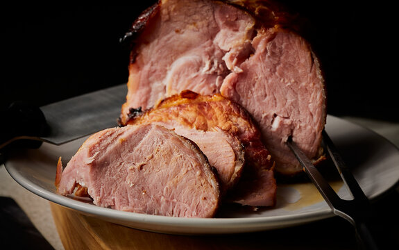 Honey and mustard roast gammon joint resting on serving plate.