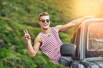 Take it easy wherever you go. Portrait of a young man leaning out the window of a car while on a...