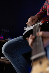 Man playing electric guitar. Musician at record studio holding electric guitar