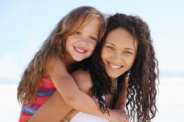 Making the most of their summer holiday. A young mother and daughter smiling at the beach.