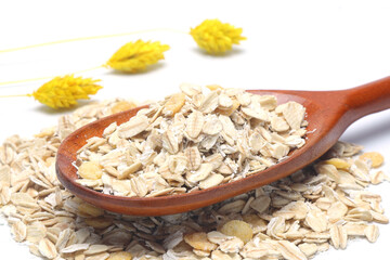 Breakfast cereals in wooden spoon. Healthy muesli with oat flakes, nuts and raisins isolated on white background.