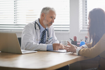 Obraz premium Dedicated to the health of his patients. Shot of a doctor meeting with his patient.