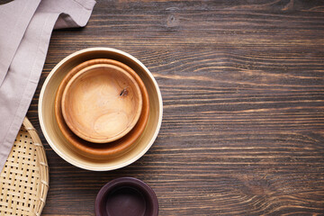 Modern wooden crockery, trendy tableware with space for text. Dishes for serving and eating meals on a wooden background, top view.