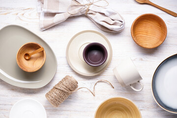 Dishes for serving and eating meals, top view. Modern ceramic and wooden crockery, trendy tableware.